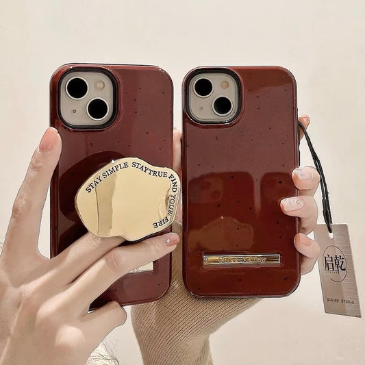 The red geometric stand is attached to the back of the phone case